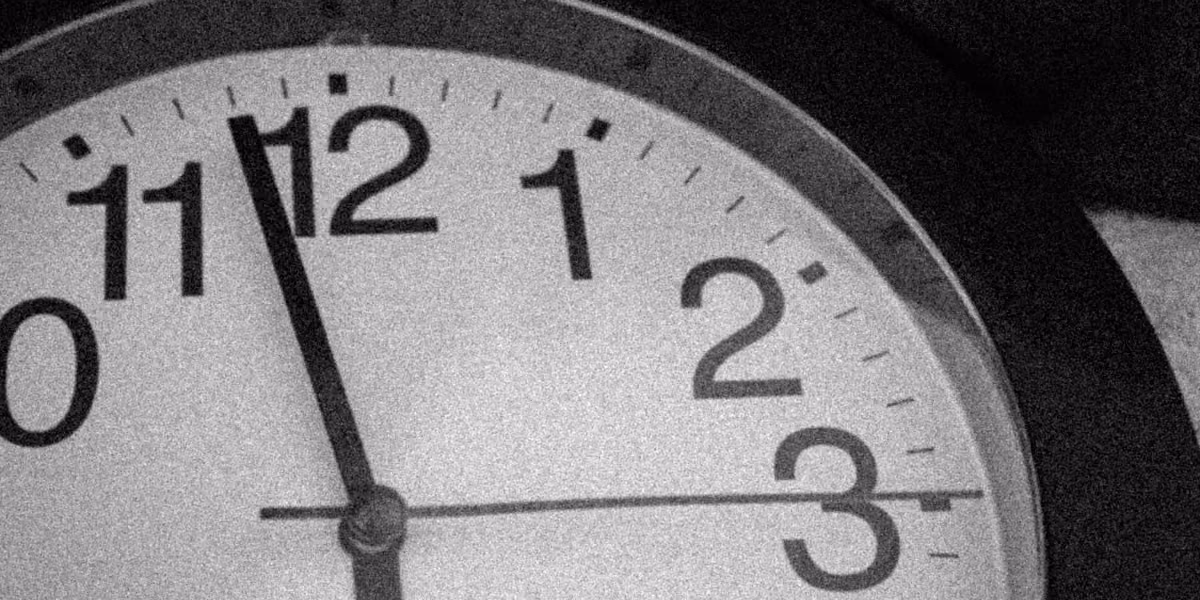 Close-up of a clock face showing the time as 11:57:15.